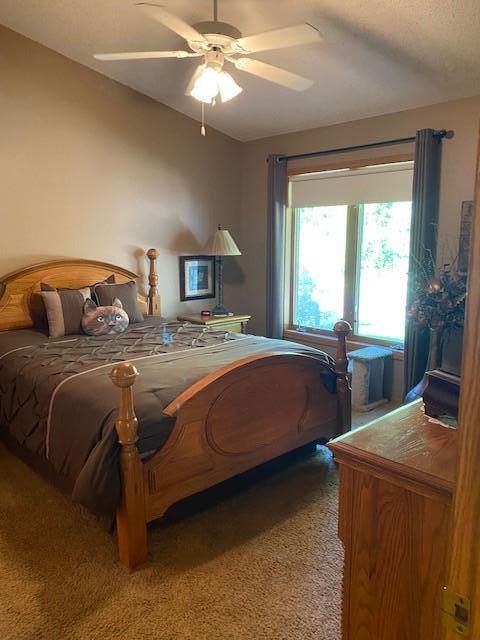 bedroom featuring light colored carpet and ceiling fan