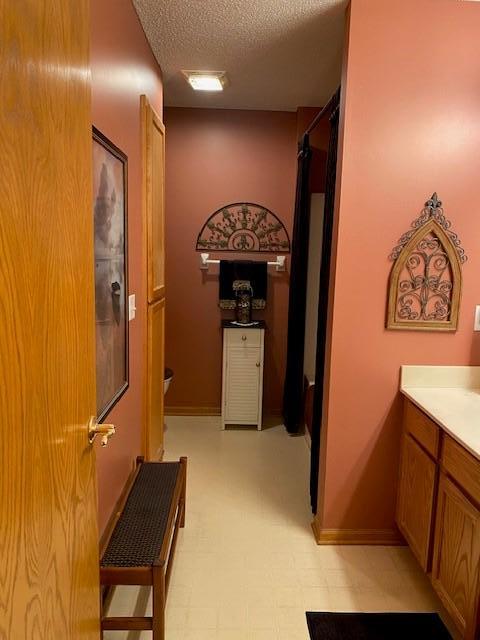 full bath with vanity, tile patterned floors, walk in shower, and a textured ceiling