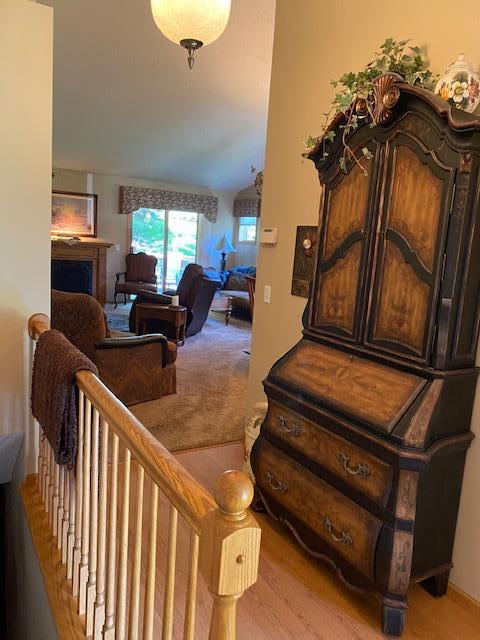 sitting room featuring an upstairs landing, carpet, and a fireplace