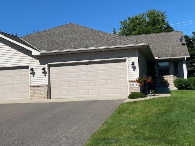 single story home featuring an attached garage, brick siding, and a shingled roof