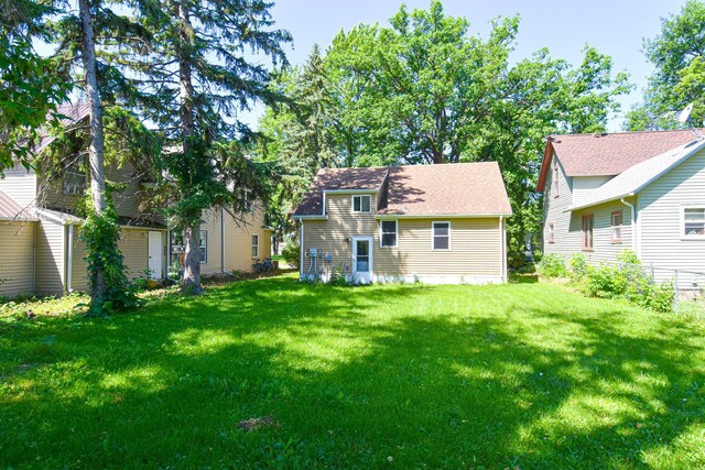 rear view of property with a yard