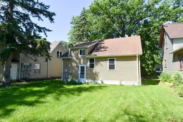 back of house featuring a lawn