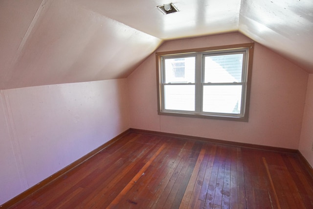 additional living space with dark wood-type flooring and vaulted ceiling