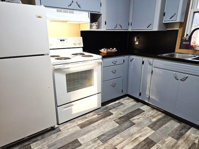 kitchen featuring dark hardwood / wood-style flooring, sink, extractor fan, and white appliances