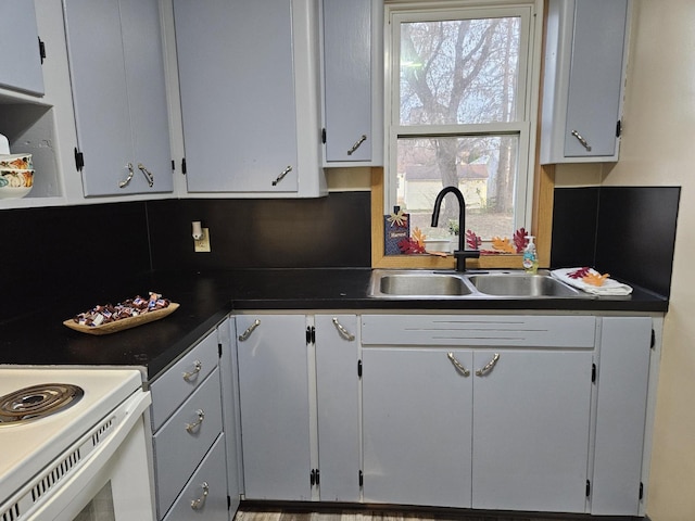 kitchen with backsplash, sink, and white range with electric stovetop