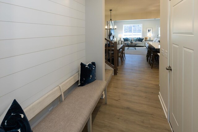 corridor with an inviting chandelier and hardwood / wood-style flooring