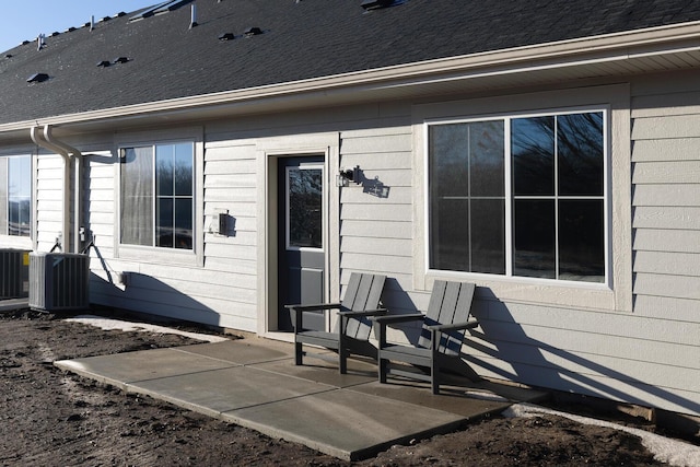 view of exterior entry featuring cooling unit and a patio area