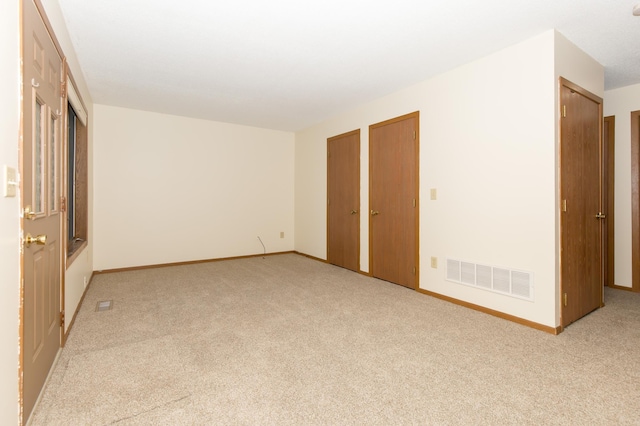 1600 Roundhouse Cir, Shakopee, MN 55379 - unfurnished bedroom featuring baseboards, light carpet, multiple closets, and visible vents
