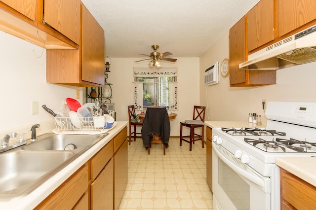 1600 Roundhouse Cir, Shakopee, MN 55379 - kitchen featuring white gas stove, a sink, light countertops, light floors, and under cabinet range hood