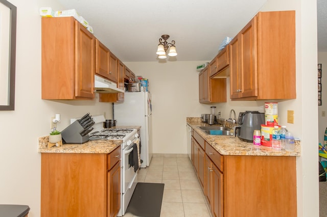 1600 Roundhouse Cir, Shakopee, MN 55379 - kitchen with brown cabinets, a sink, white gas range oven, under cabinet range hood, and light tile patterned flooring