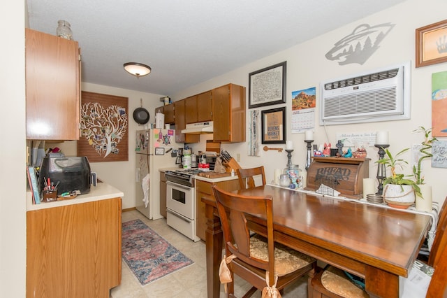 1600 Roundhouse Cir, Shakopee, MN 55379 - kitchen with brown cabinets, white appliances, light countertops, under cabinet range hood, and a wall mounted AC