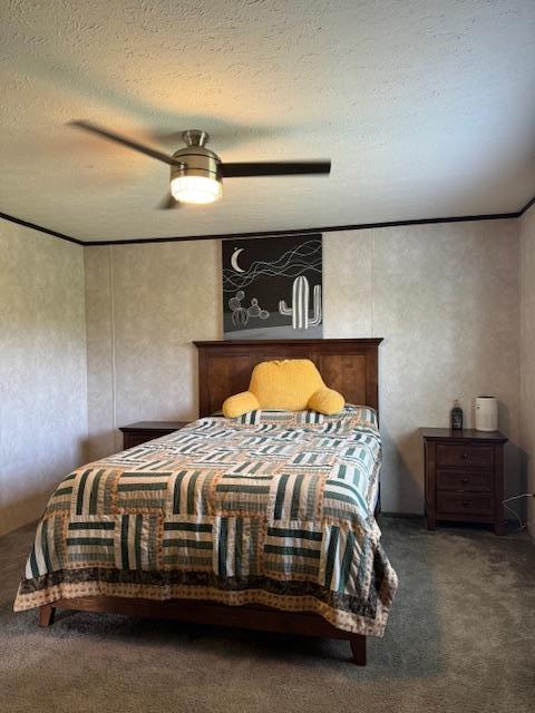 bedroom featuring dark colored carpet, ceiling fan, and a textured ceiling