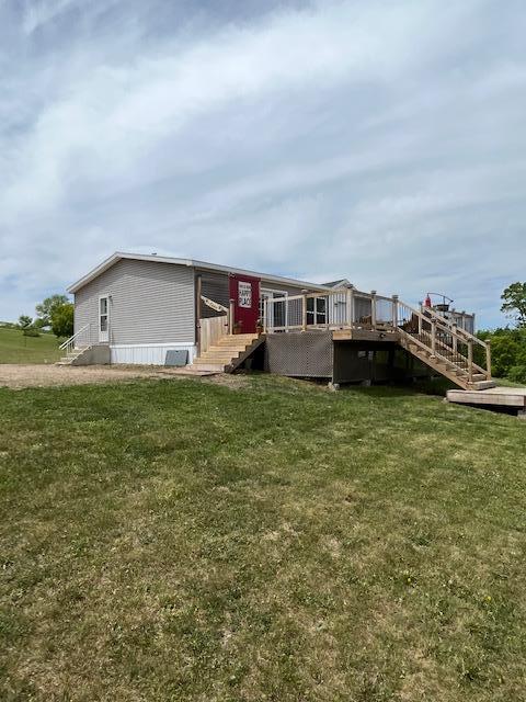 view of front of property featuring a deck and a front lawn