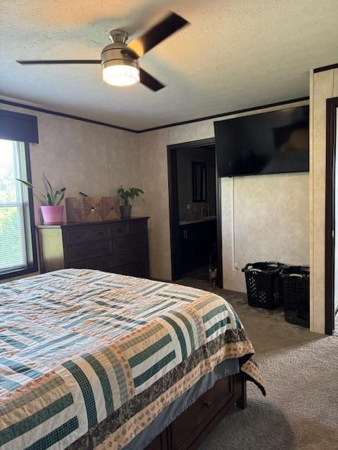 carpeted bedroom featuring ceiling fan and a textured ceiling