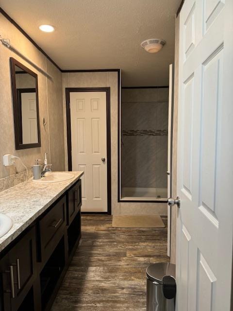 bathroom with hardwood / wood-style floors, vanity, an enclosed shower, and a textured ceiling