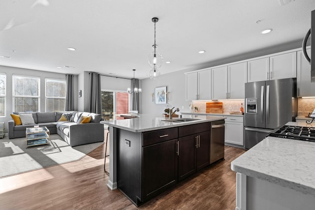 kitchen with white cabinets, sink, light stone counters, and stainless steel appliances