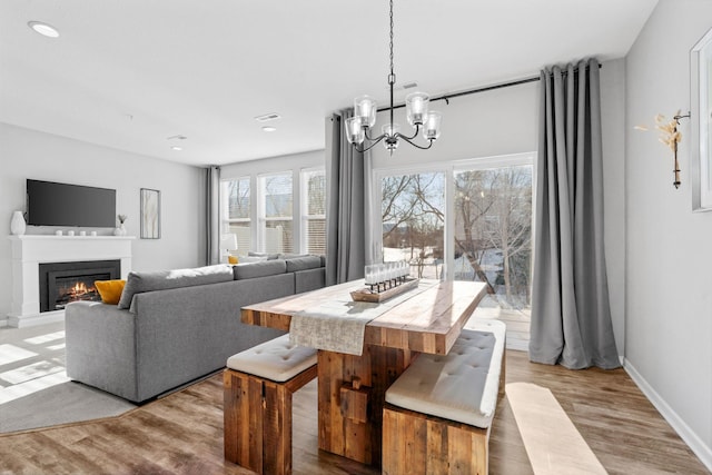 dining room with light wood-type flooring and a chandelier