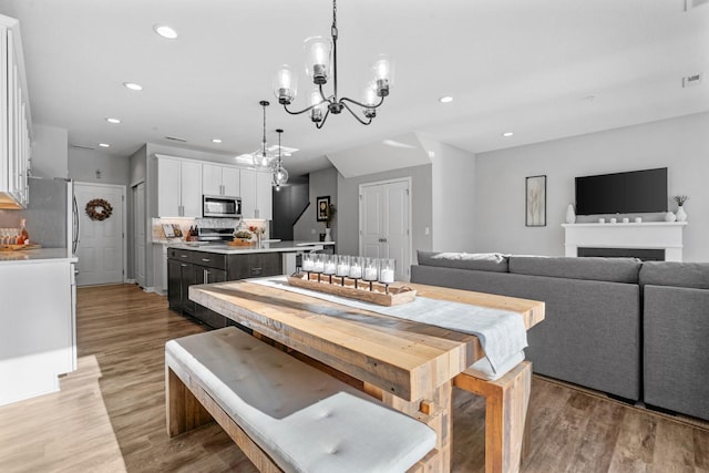 dining area featuring an inviting chandelier and light hardwood / wood-style floors