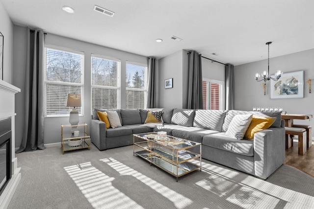 living room with light carpet and a chandelier