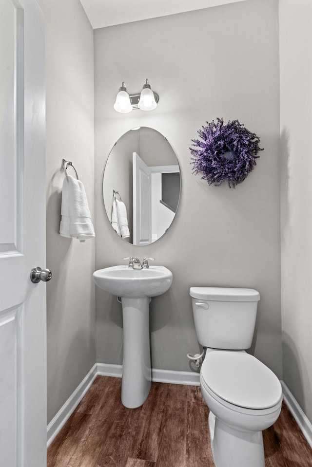 bathroom with toilet, sink, and hardwood / wood-style floors