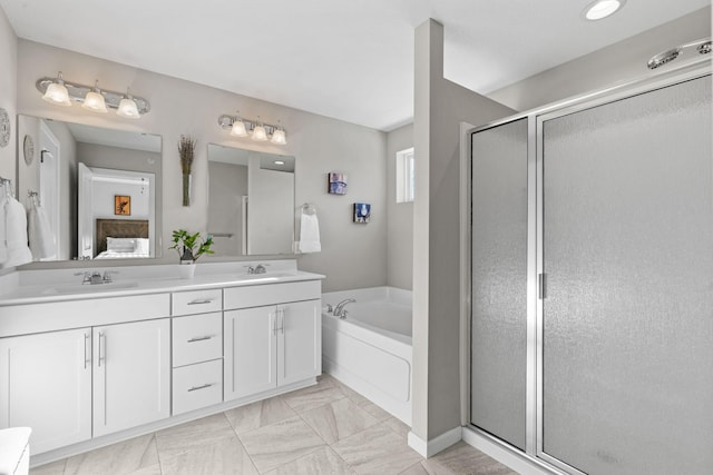 bathroom featuring vanity and independent shower and bath