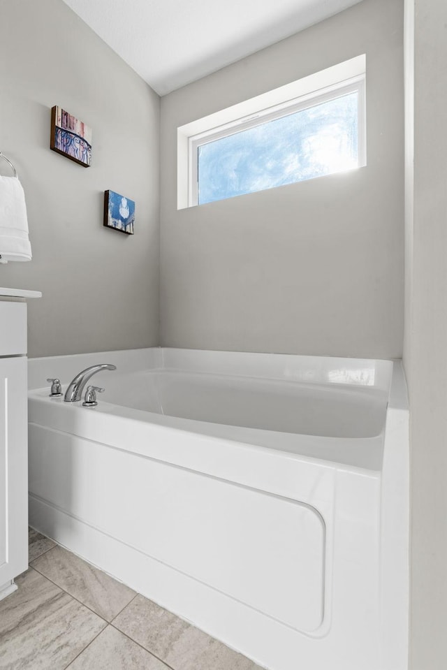 bathroom featuring tile patterned floors and a tub