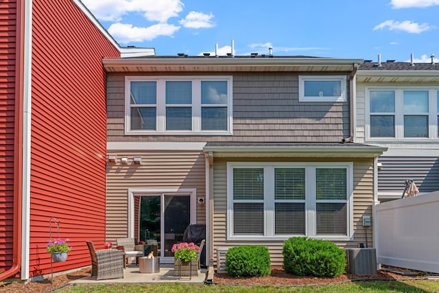 rear view of house with central AC unit and a patio