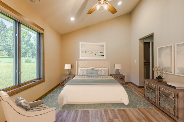bedroom featuring multiple windows, wood finished floors, baseboards, and vaulted ceiling