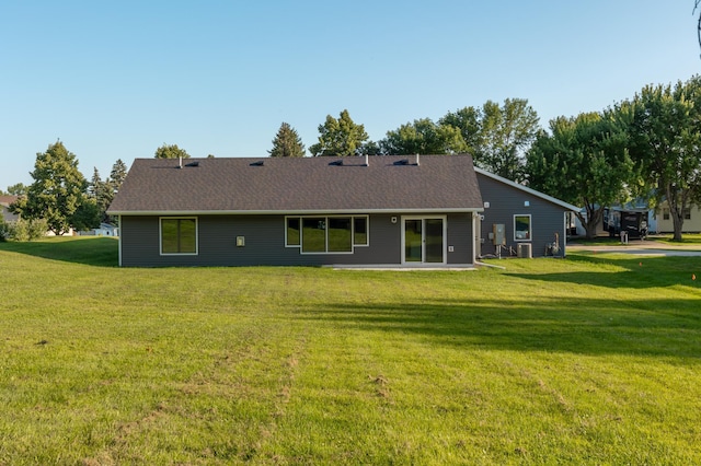 rear view of property with a lawn and a shingled roof