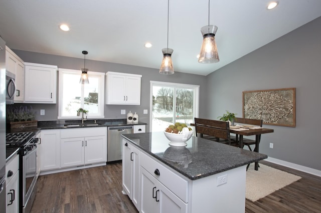 kitchen with lofted ceiling, a center island, dark hardwood / wood-style floors, stainless steel appliances, and sink