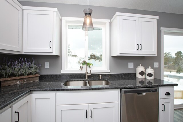 kitchen featuring white cabinets, pendant lighting, dishwashing machine, and sink