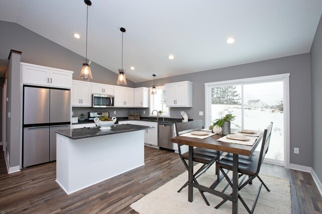 kitchen with appliances with stainless steel finishes, dark hardwood / wood-style floors, and white cabinetry