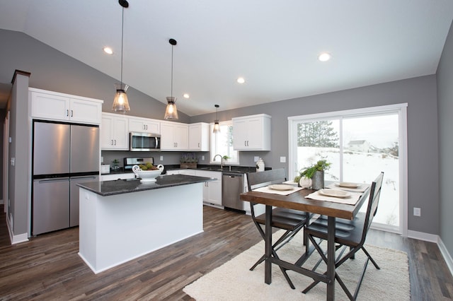 kitchen with sink, white cabinetry, decorative light fixtures, a center island, and appliances with stainless steel finishes