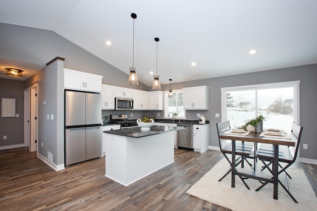 kitchen featuring white cabinets, decorative light fixtures, dark hardwood / wood-style flooring, and appliances with stainless steel finishes