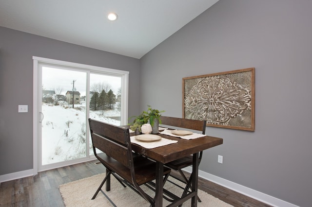 dining area with high vaulted ceiling and wood-type flooring