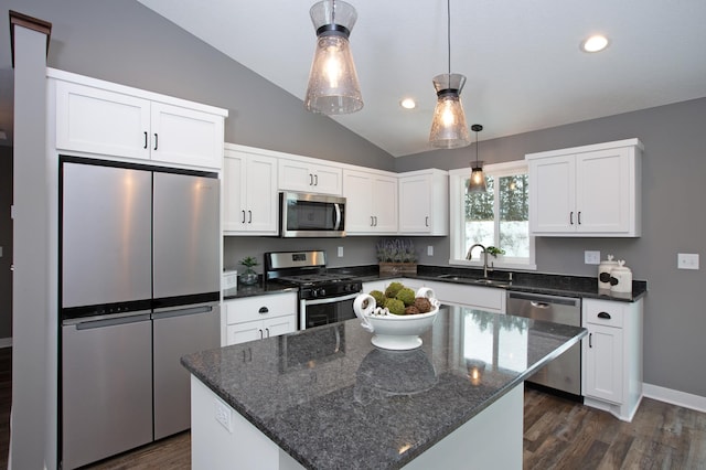 kitchen featuring white cabinetry, sink, appliances with stainless steel finishes, a center island, and vaulted ceiling