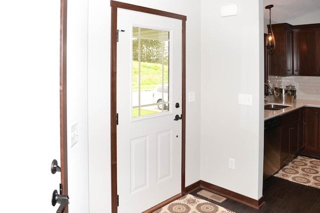 entryway featuring dark wood-type flooring, a healthy amount of sunlight, and sink