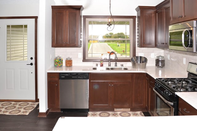 kitchen featuring sink, appliances with stainless steel finishes, pendant lighting, and tasteful backsplash