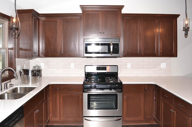 kitchen with sink, decorative backsplash, hanging light fixtures, and appliances with stainless steel finishes