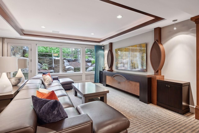 living room featuring crown molding, light colored carpet, and a raised ceiling