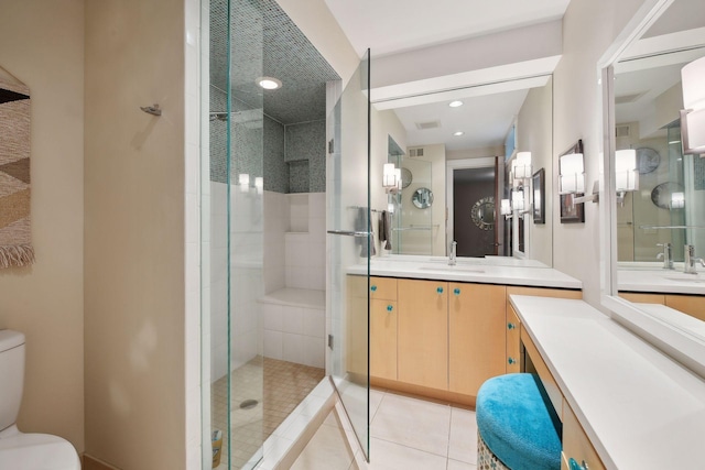 bathroom featuring vanity, a shower with shower door, toilet, and tile patterned flooring