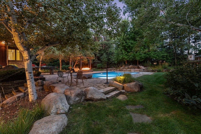 view of pool with a patio and a lawn