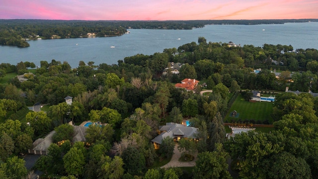 aerial view at dusk featuring a water view