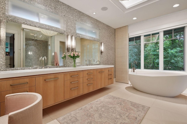 bathroom with tile patterned flooring, double vanity, a shower stall, a freestanding tub, and recessed lighting