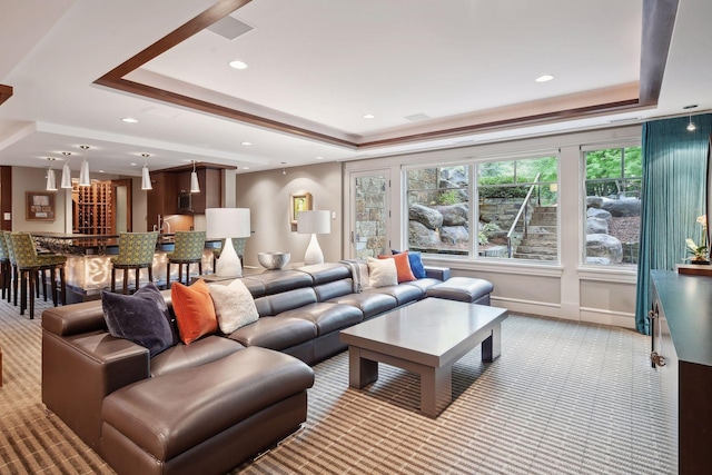 living room with a tray ceiling, carpet, and recessed lighting