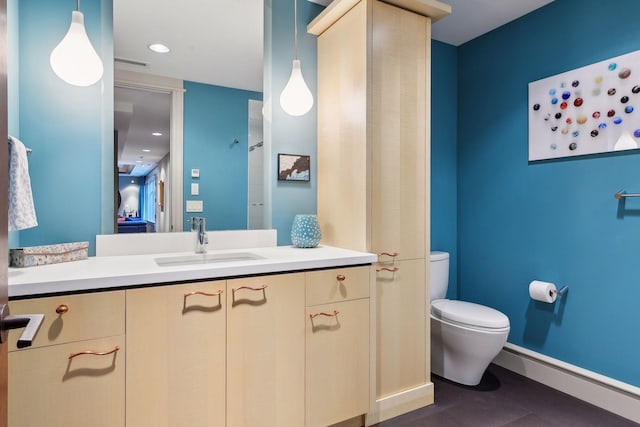 bathroom with baseboard heating, toilet, vanity, and baseboards