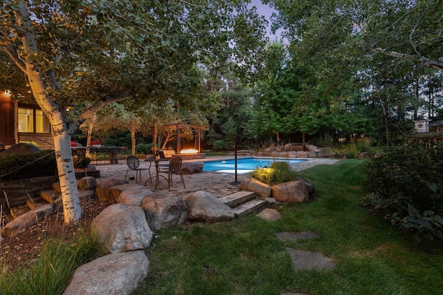 swimming pool with a patio area and a yard