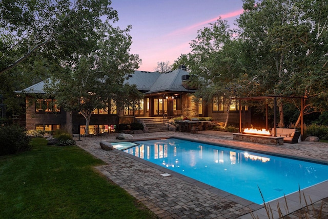 swimming pool featuring an outdoor fire pit, a patio, and a yard