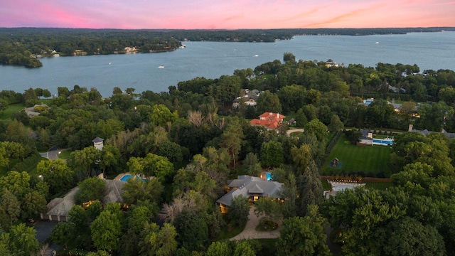 aerial view at dusk of a water view and a view of trees