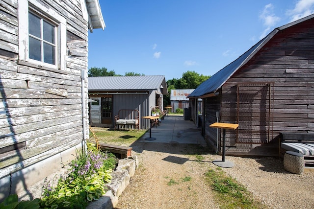 view of property exterior featuring an outbuilding and a patio